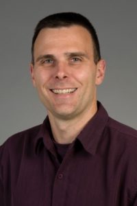 Dr. Matt Kaeberlein, Professor, Department of Pathology, University of Washington, and Director of the Dog Aging Project. Short dark hair, smiling.