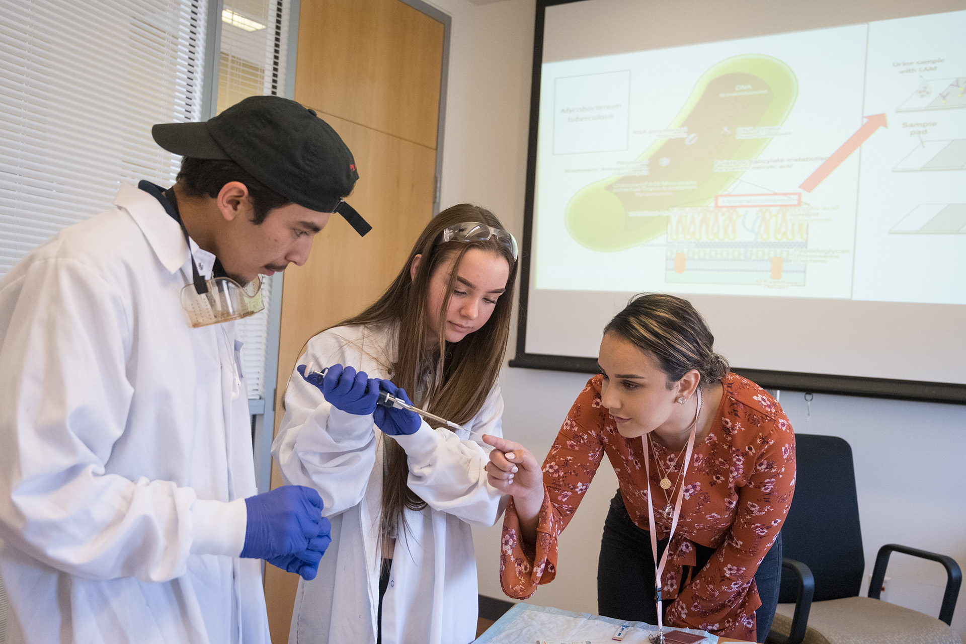 Danara Flores, Senior Microbiology major, helps high school students learn to use a test for Tuberculosis at Colorado State University's Research Innovation Center on World TB Day, March 25, 2019