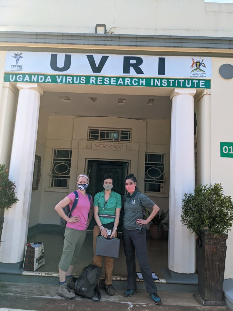 three scientists stand outside virus research institute