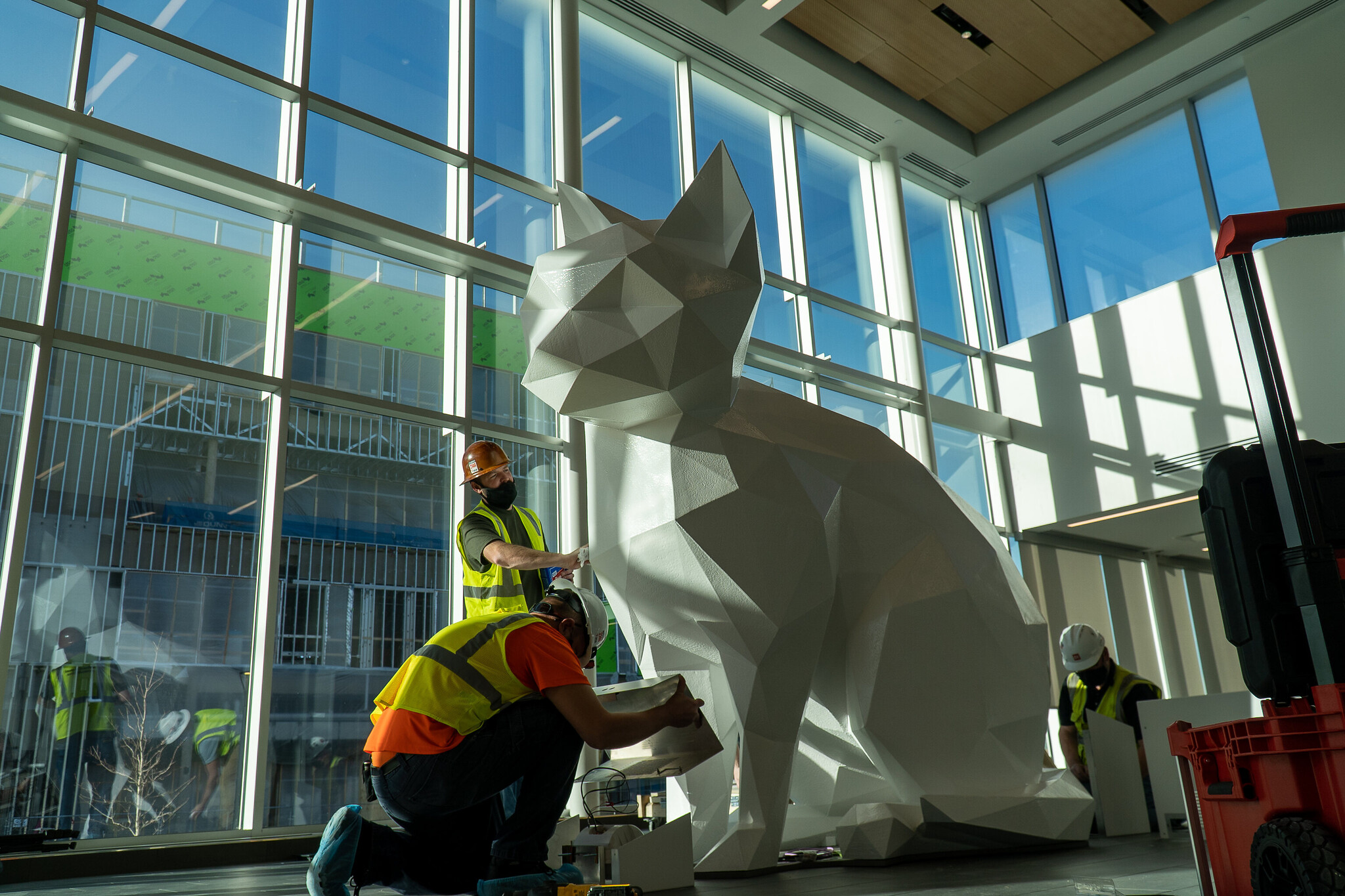 construction workers set up giant kitten installation